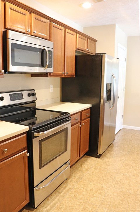 Kitchen with stainless steel microwave, stove and fridge
